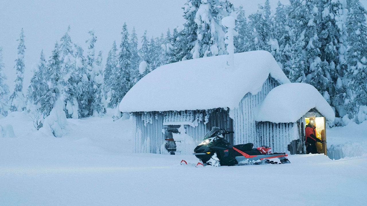 49 Ranger PRO snøscooter parkert foran en hytte i villmarka