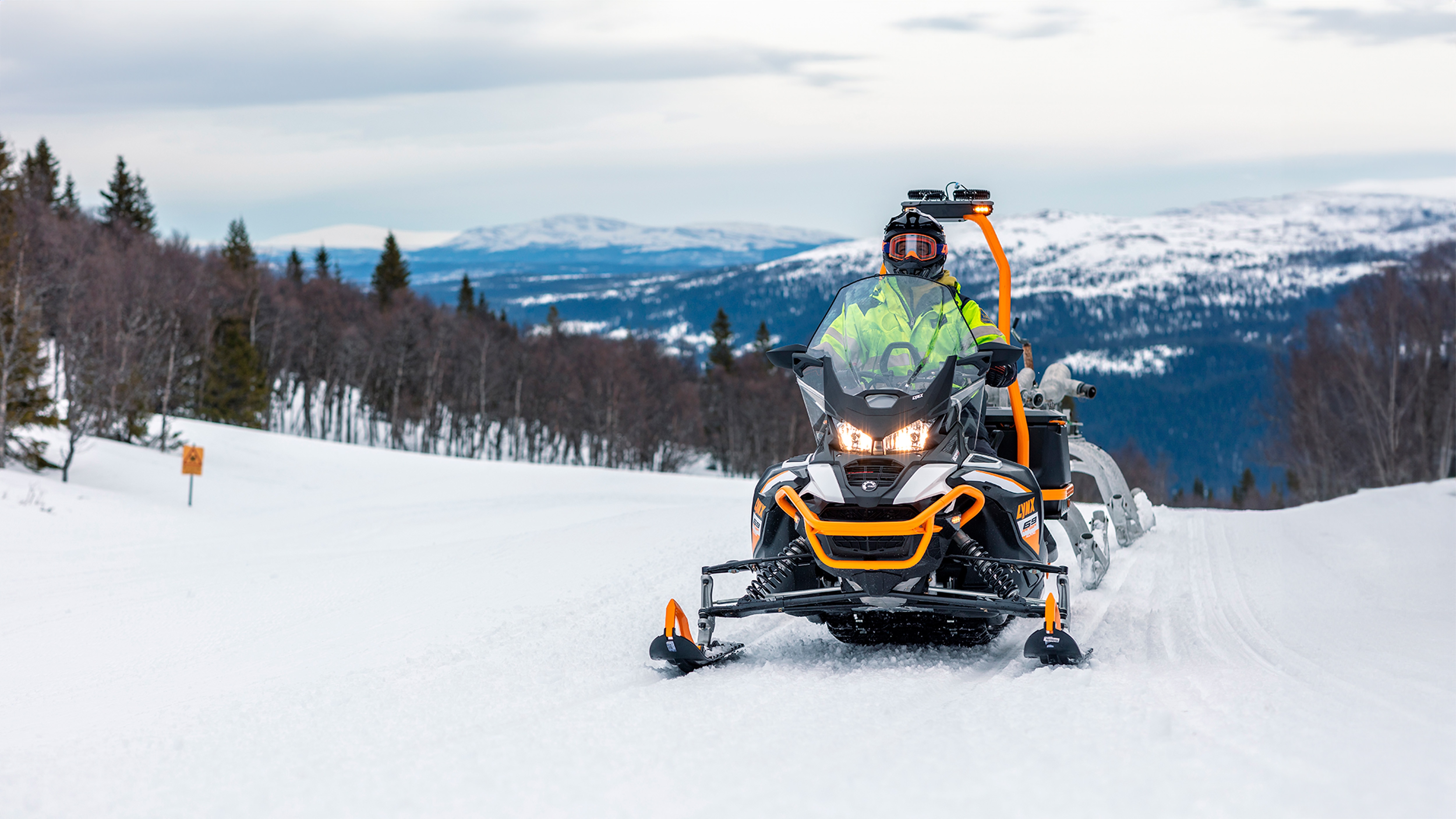 Lynx 69 Ranger Alpine snowmobile in towing work at ski resort