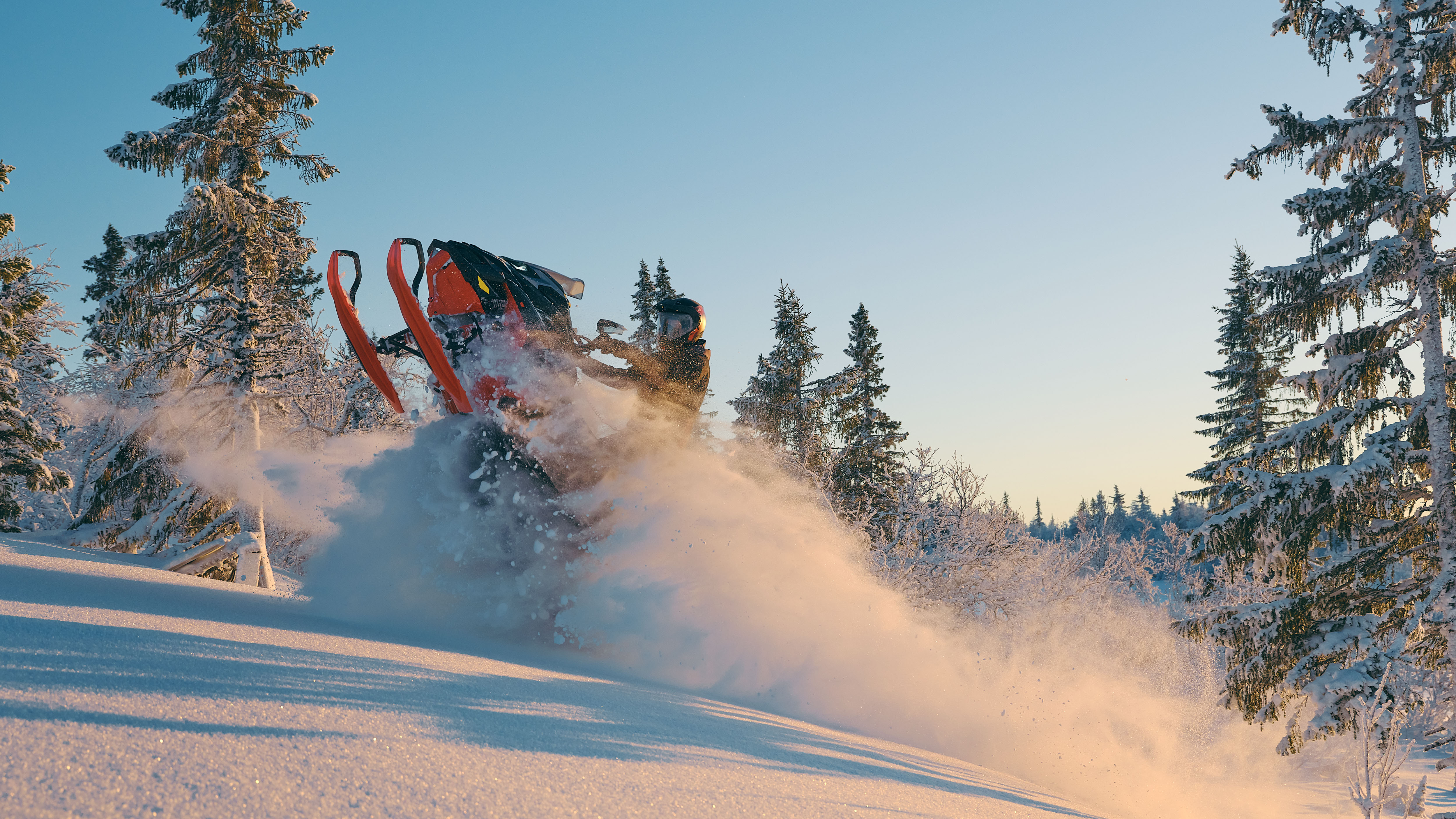 "New 2026 Lynx Brutal RE snowmobile jumping out of the snow in a snowy forest. "