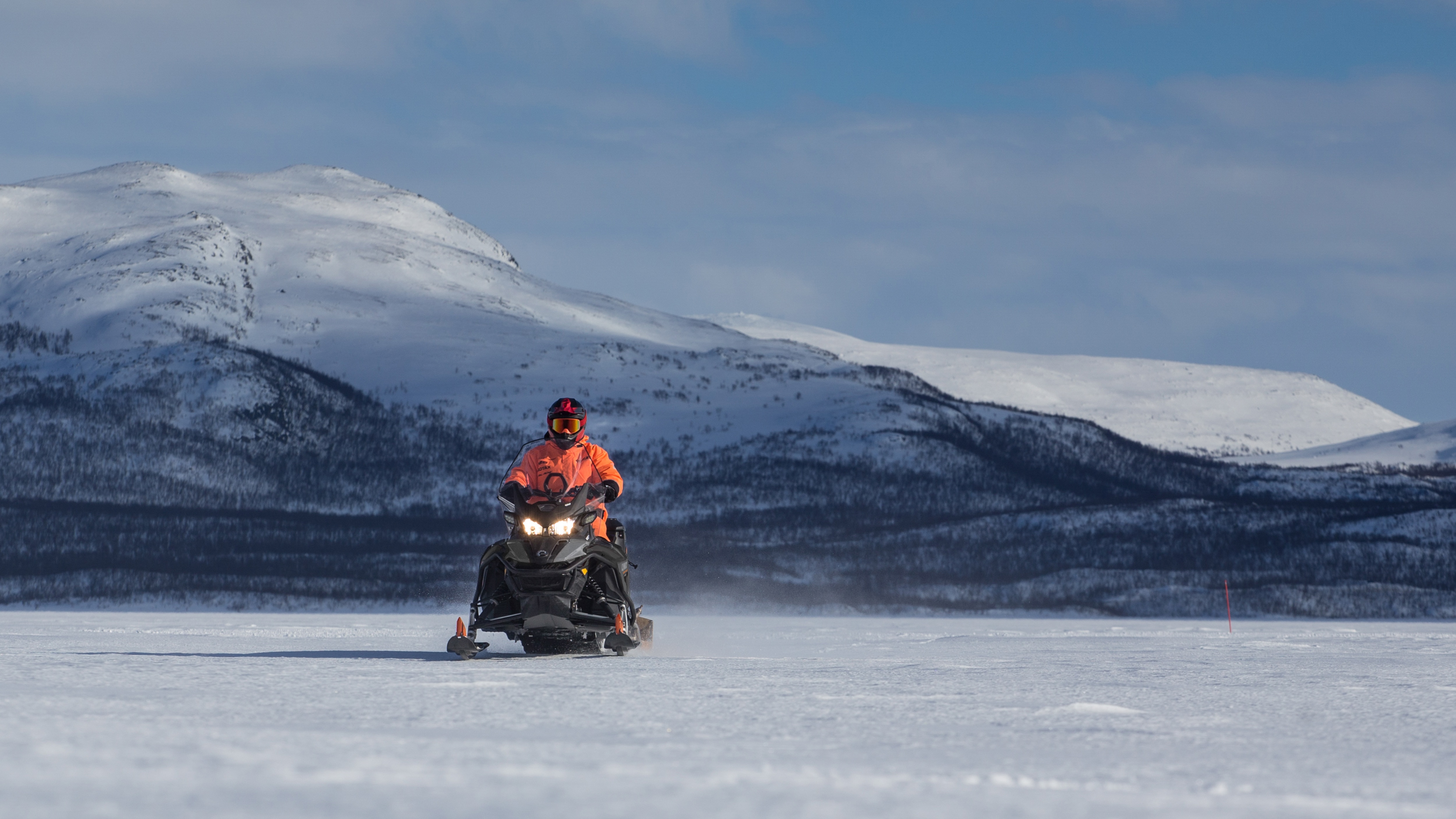 Lynx 59 Ranger snowmobile towing sleigh on lakeice