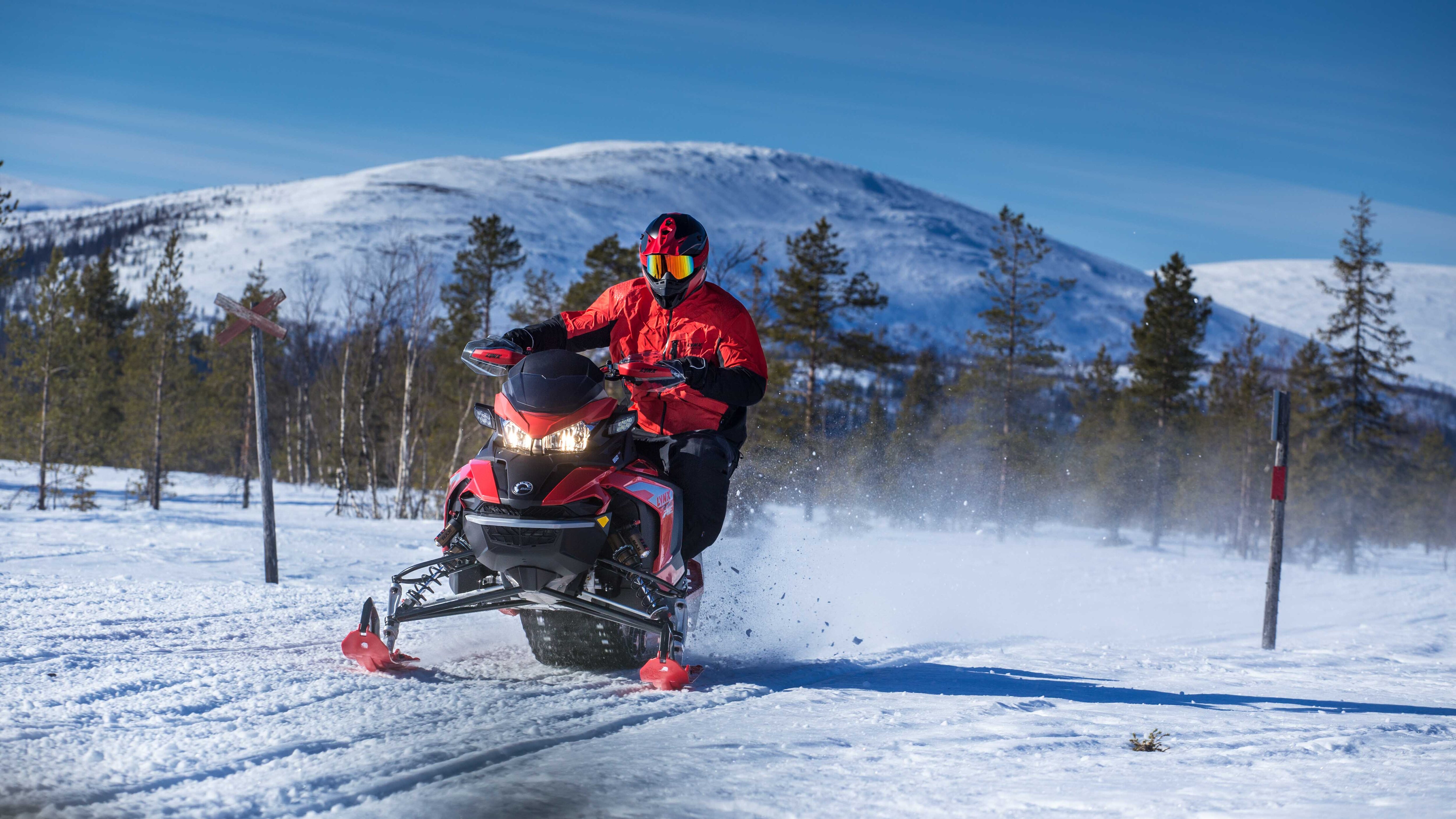 Fotbollsspelaren Sami Hyypiä Lynx snöskoterkörning på spår med utsikt över bergen