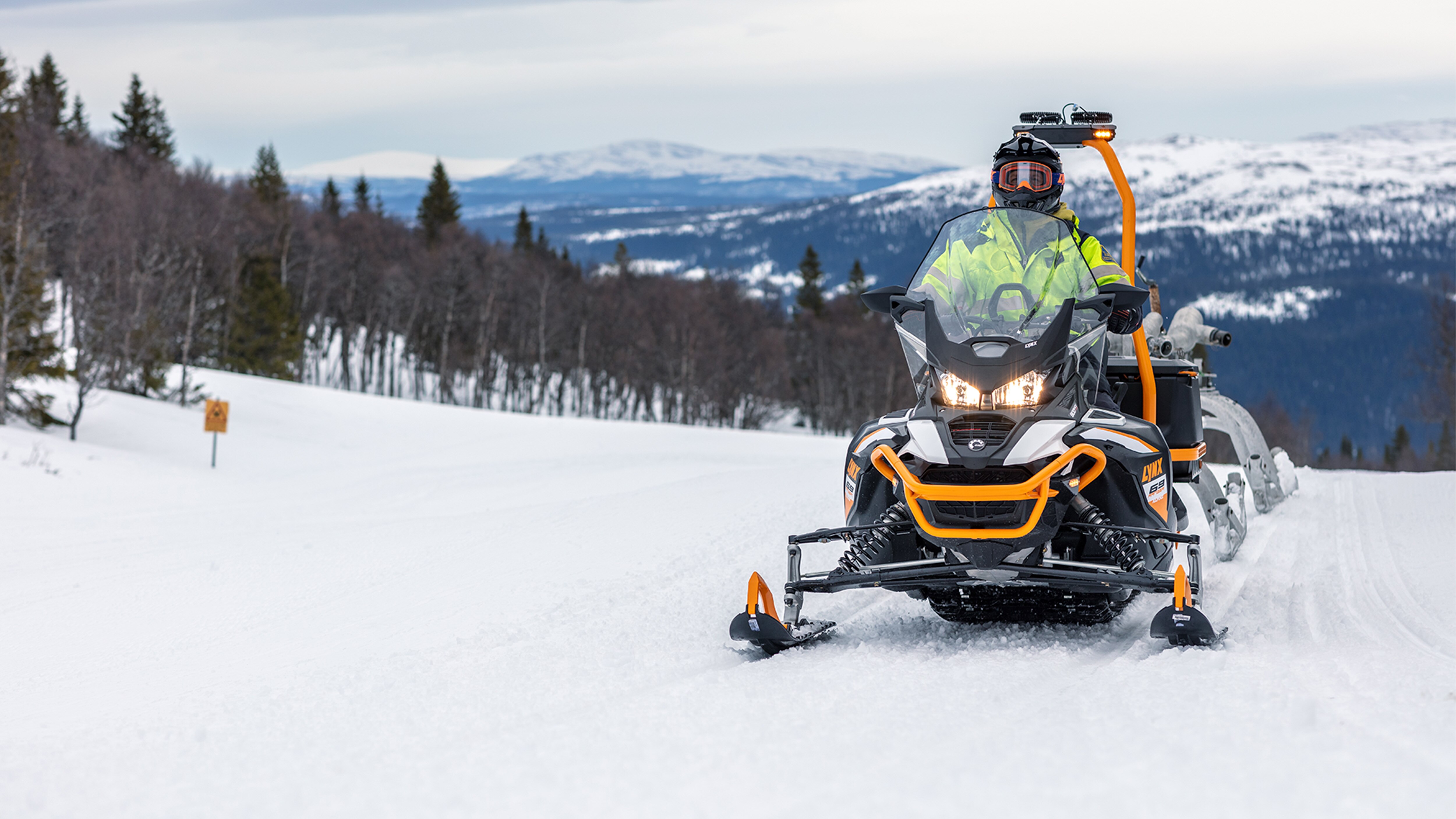 Lynx 69 Ranger Alpine snowmobile in towing work at ski resort
