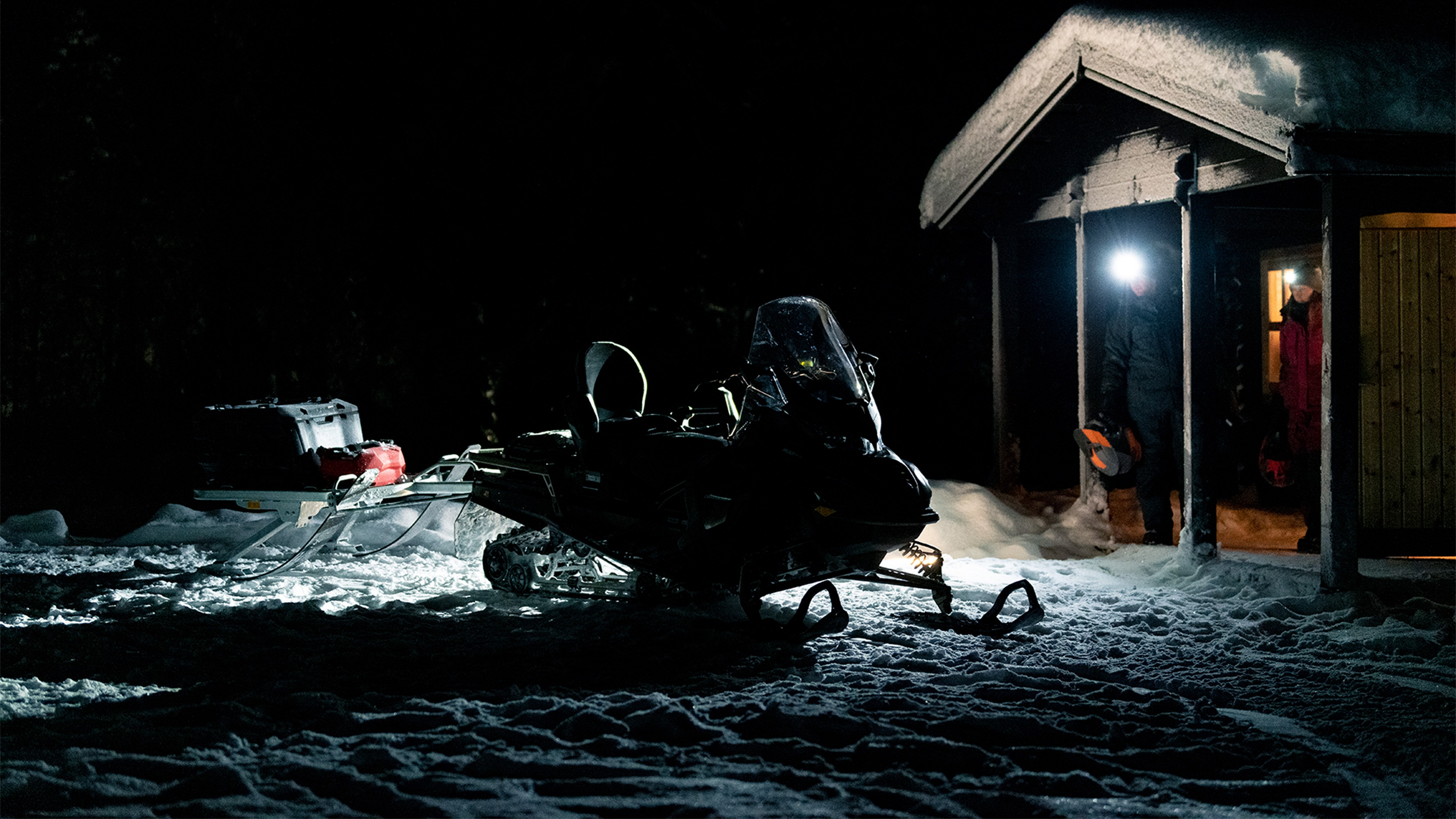 Lynx Commander at night next to a cabin