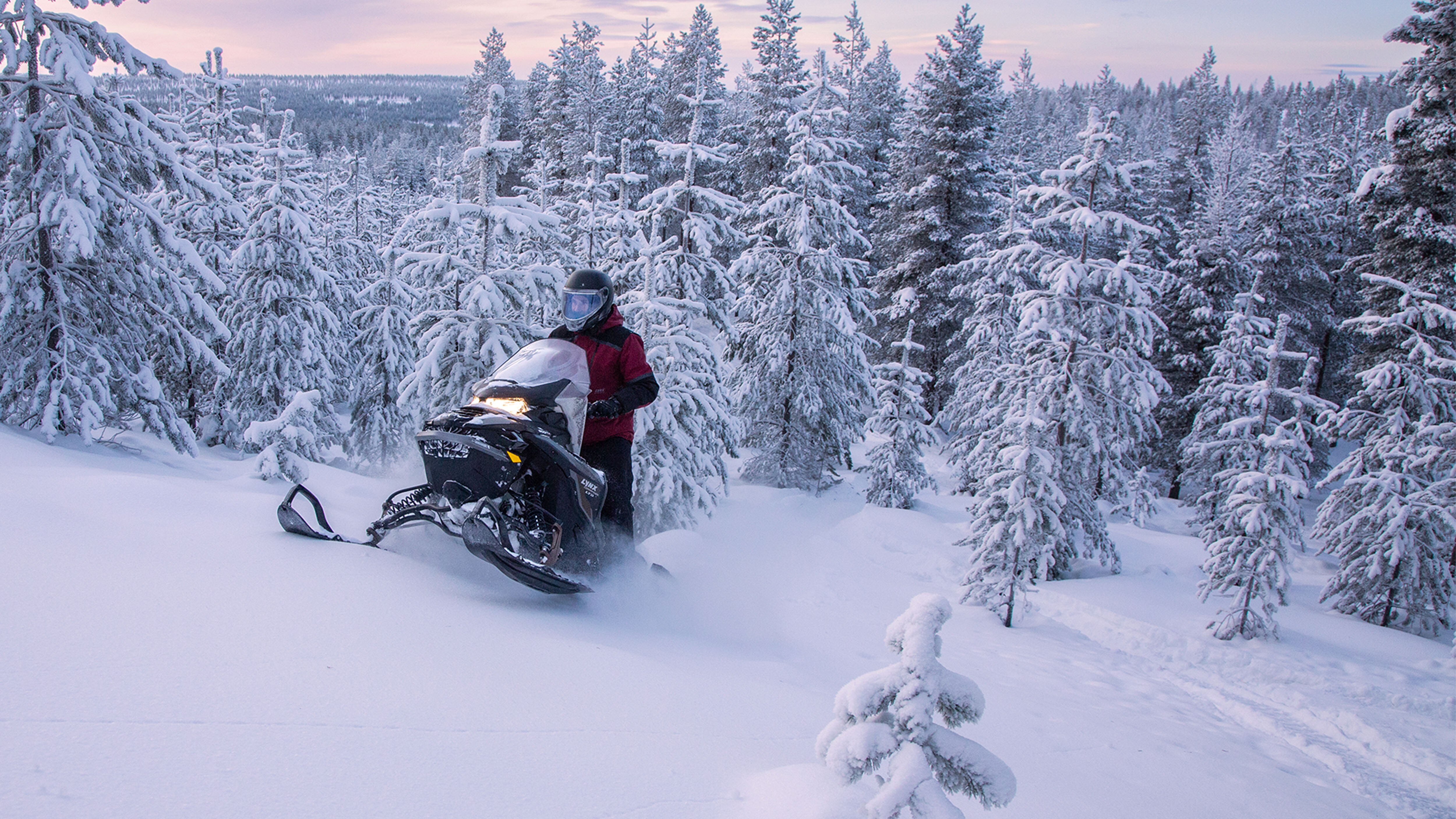 Lynx Commander klättrar uppför en kulle i djup snö